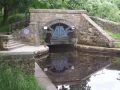 Diggle portal of the Standedge Tunnel with its very fetching gate design. The previous photo was taken from the top of the portal. Frequent (mainly two-carriage, local) trains pass through the hill in their own tunnels and run alongside the canal here. On the left side of the portal are CRT boat services, including that useful fresh water so that a boat can fill up its water tank and so be low down in the water, ready for the tunnel passage! - Location: Diggle - Canal: Huddersfield Narrow
