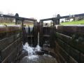 The canal was very full as we came down the Bosley flight and as we let water out from each lock it overfilled the pound below - here it is pouring over the top gates as we empty the lock. - Location: Bosley Locks - Canal: Macclesfield